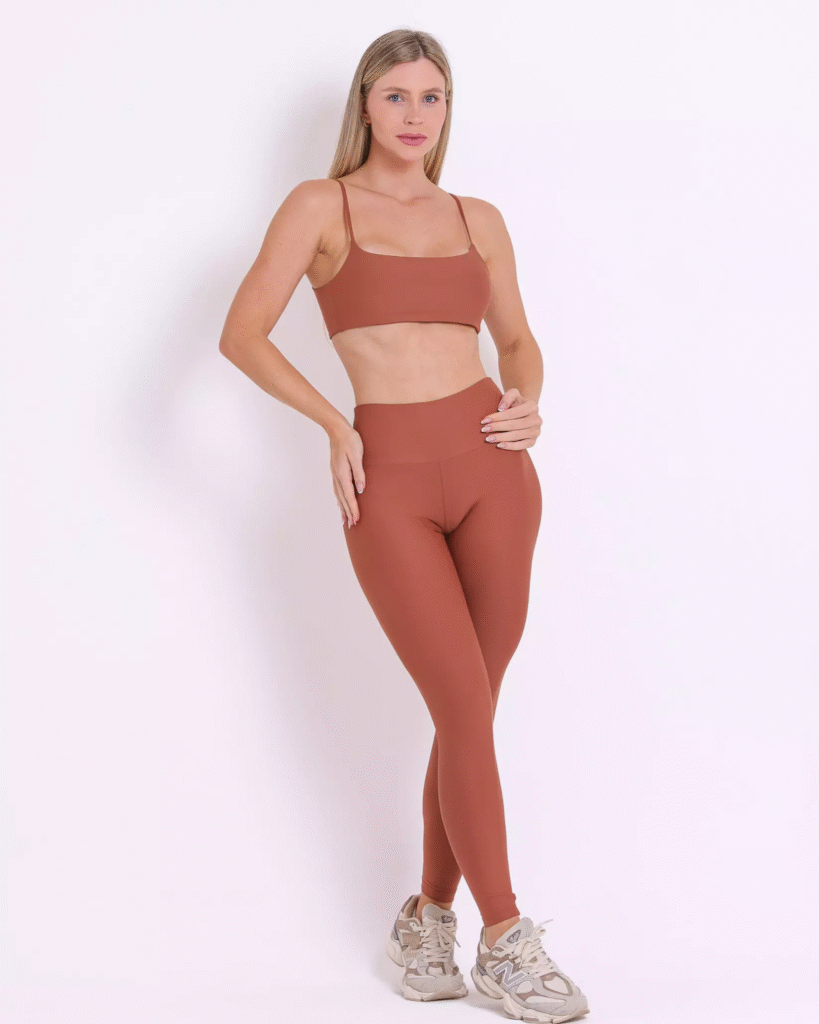 A modelo está usando o Conjunto Calça Legging Básica Light + Top Ju - Caramelo